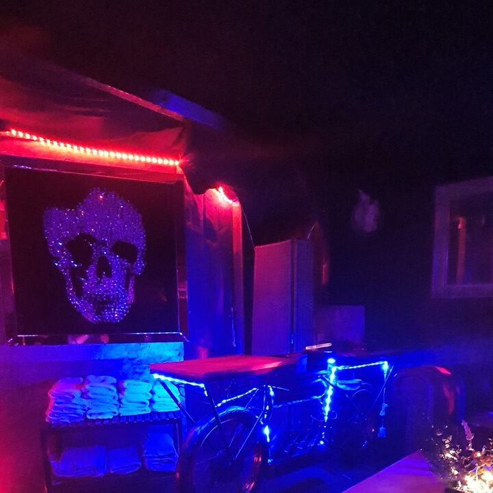 Dunkle Lounge mit Handtüchern, Tisch und Lichtleisten.