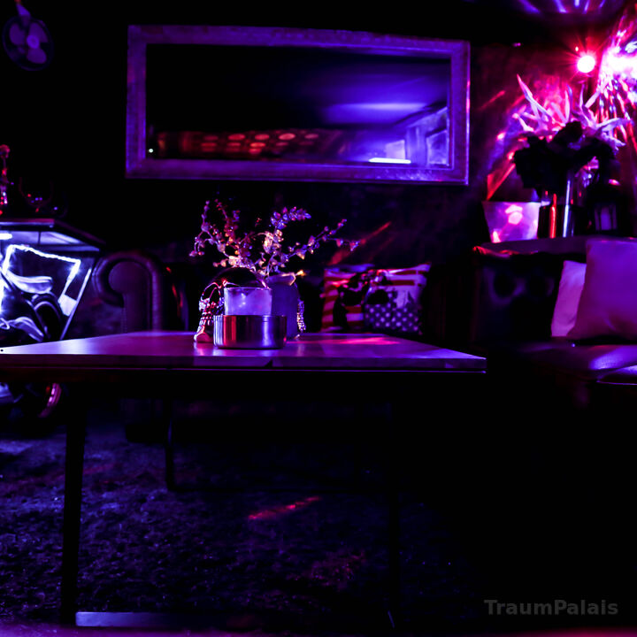 Lounge bei Abendlicht mit Sofa, Spiegel und Tisch.